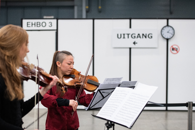 910150 Afbeelding van violisten in de XL- vaccinatielocatie in de Jaarbeurs te Utrecht, waar live klassieke muziek ...